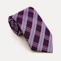 A rolled George Neale purple and blue plaid silk tie.