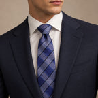 Navy Blue and Silver Plaid Silk Tie by George Neale, worn by a model with a suit and shirt