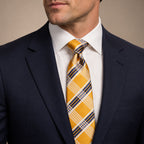 Gold and Navy Blue Plaid Silk Tie by George Neale, worn by a model with a suit and shirt