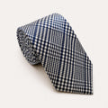 A rolled George Neale navy blue and white plaid silk tie.