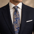 Navy and Gold Floral Silk Tie by George Neale, worn by a model with a suit and shirt