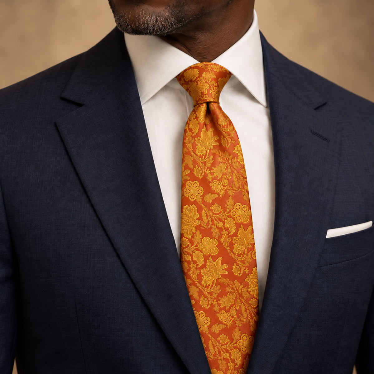 Orange and Gold Floral Silk Tie by George Neale, worn by a model with a suit and shirt