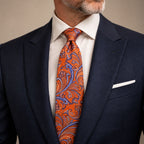 Orange and Blue Floral Silk Tie by George Neale, worn by a model with a suit and shirt