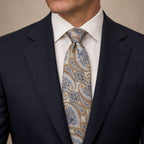 Champagne and Blue Floral Silk Tie by George Neale, worn by a model with a suit and shirt