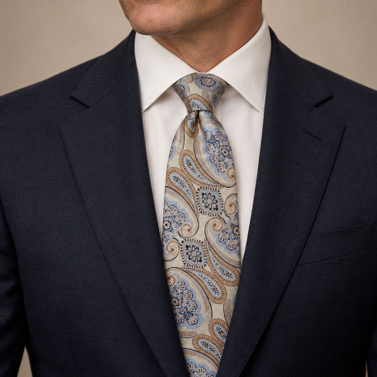 Champagne and Blue Floral Silk Tie by George Neale, worn by a model with a suit and shirt