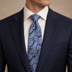 Navy and Light Blue Floral Silk Tie by George Neale, worn by a model with a suit and shirt