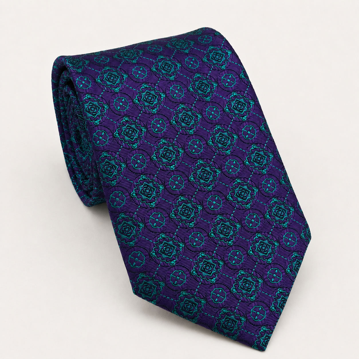 A rolled George Neale purple and teal patterned silk tie.