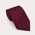 A rolled George Neale red and blue patterned silk tie.