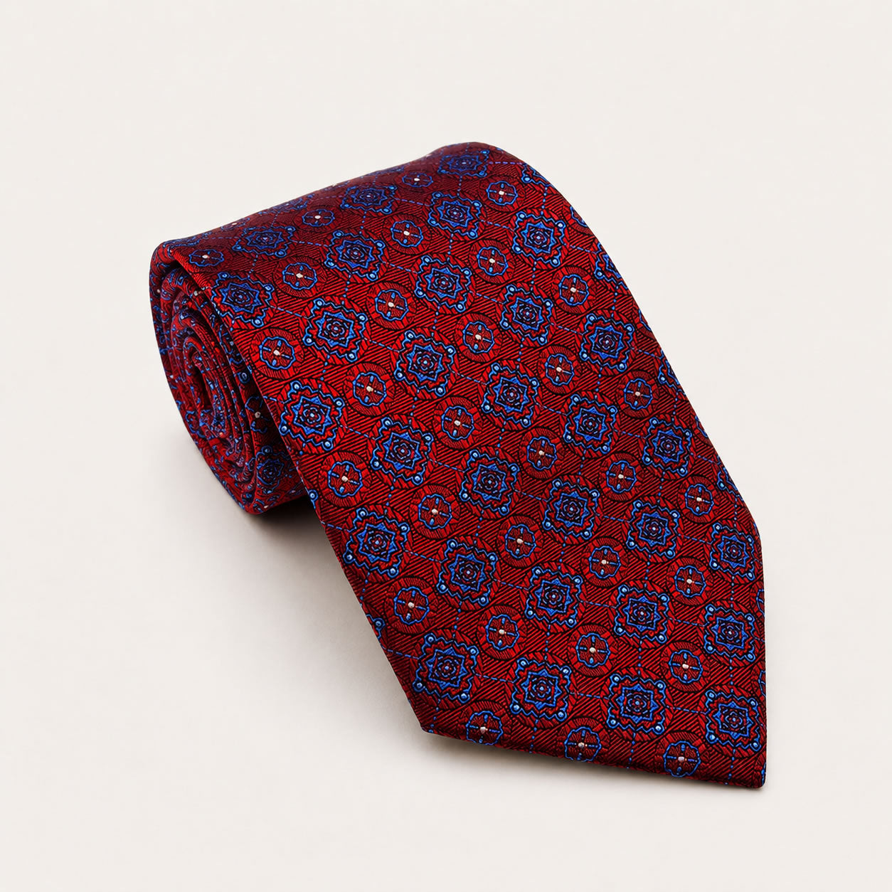 A rolled George Neale red and blue patterned silk tie.