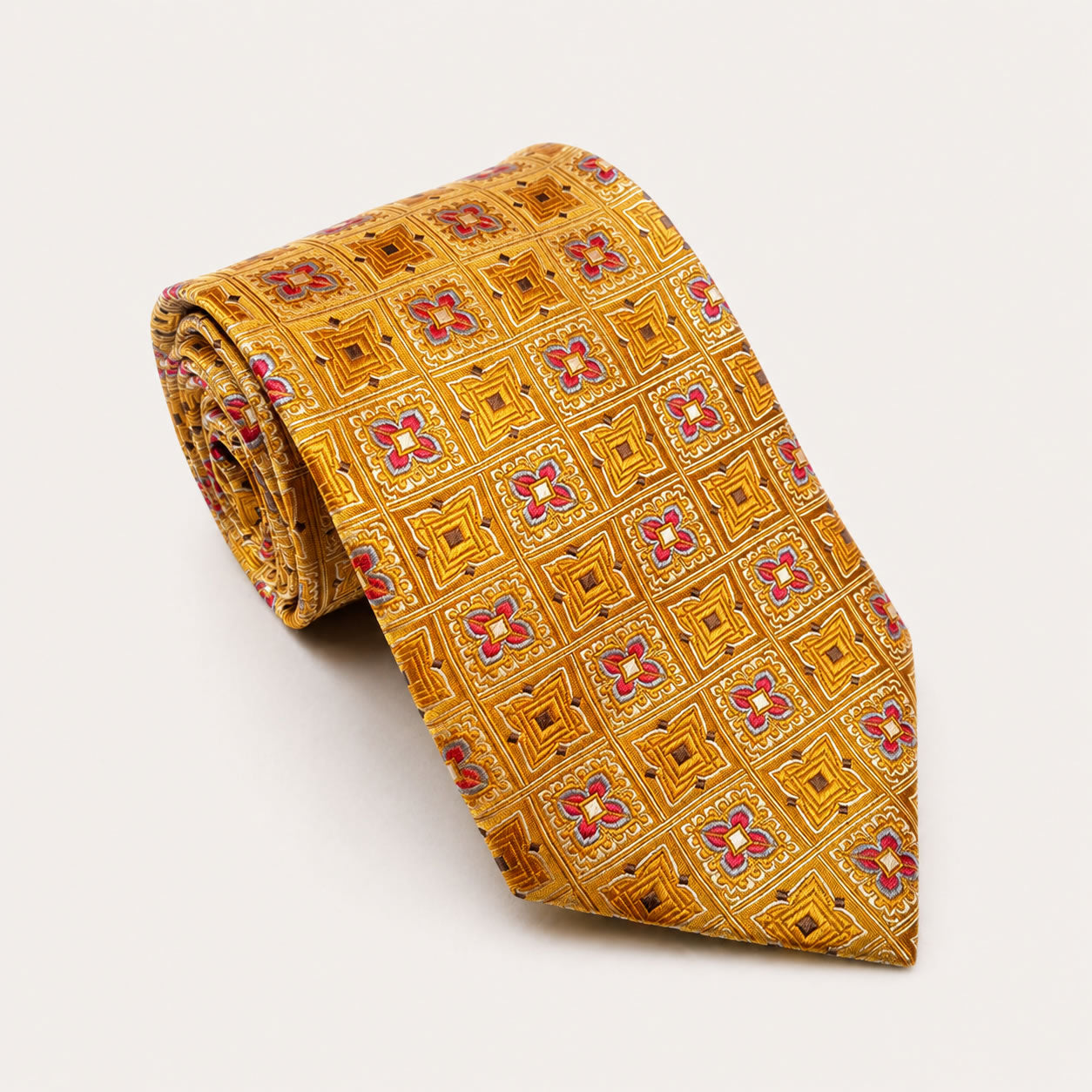 A rolled George Neale gold and pink patterned silk tie.