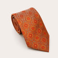 A rolled George Neale burnt orange and grey patterned silk tie.