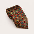 A rolled George Neale red and gold patterned silk tie.