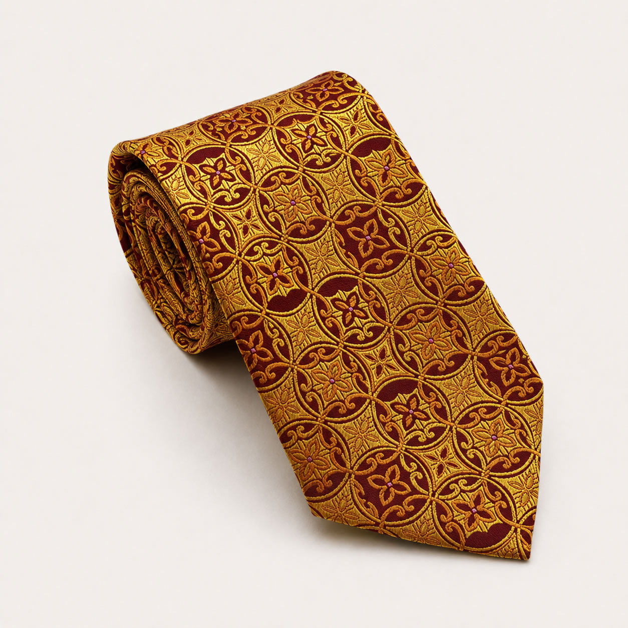 A rolled George Neale gold and burgundy patterned silk tie.