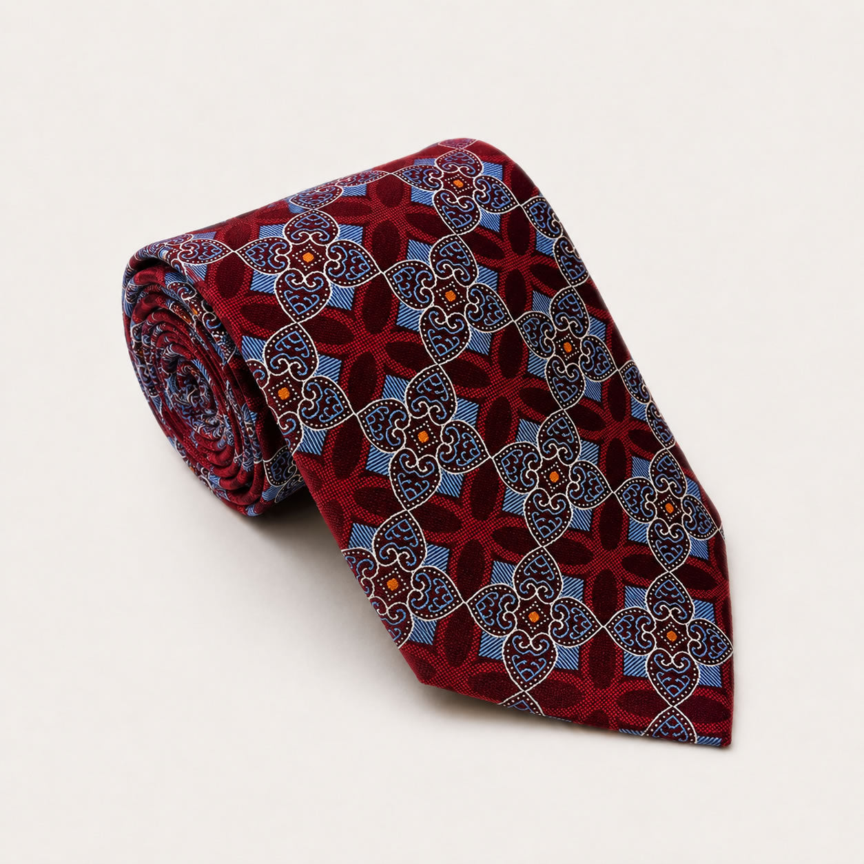 A rolled George Neale burgundy and blue patterned silk tie.