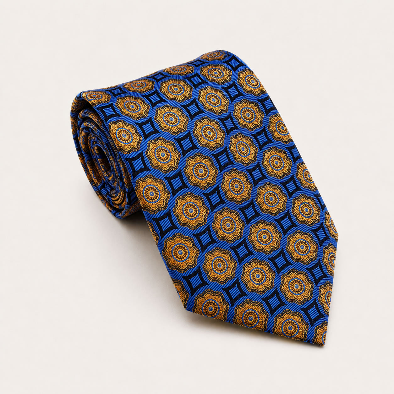 A rolled George Neale blue and gold patterned silk tie.