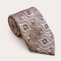 A rolled George Neale champagne and burgundy patterned silk tie.