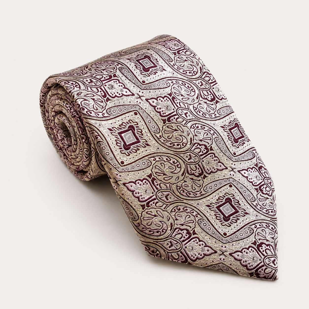A rolled George Neale champagne and burgundy patterned silk tie.