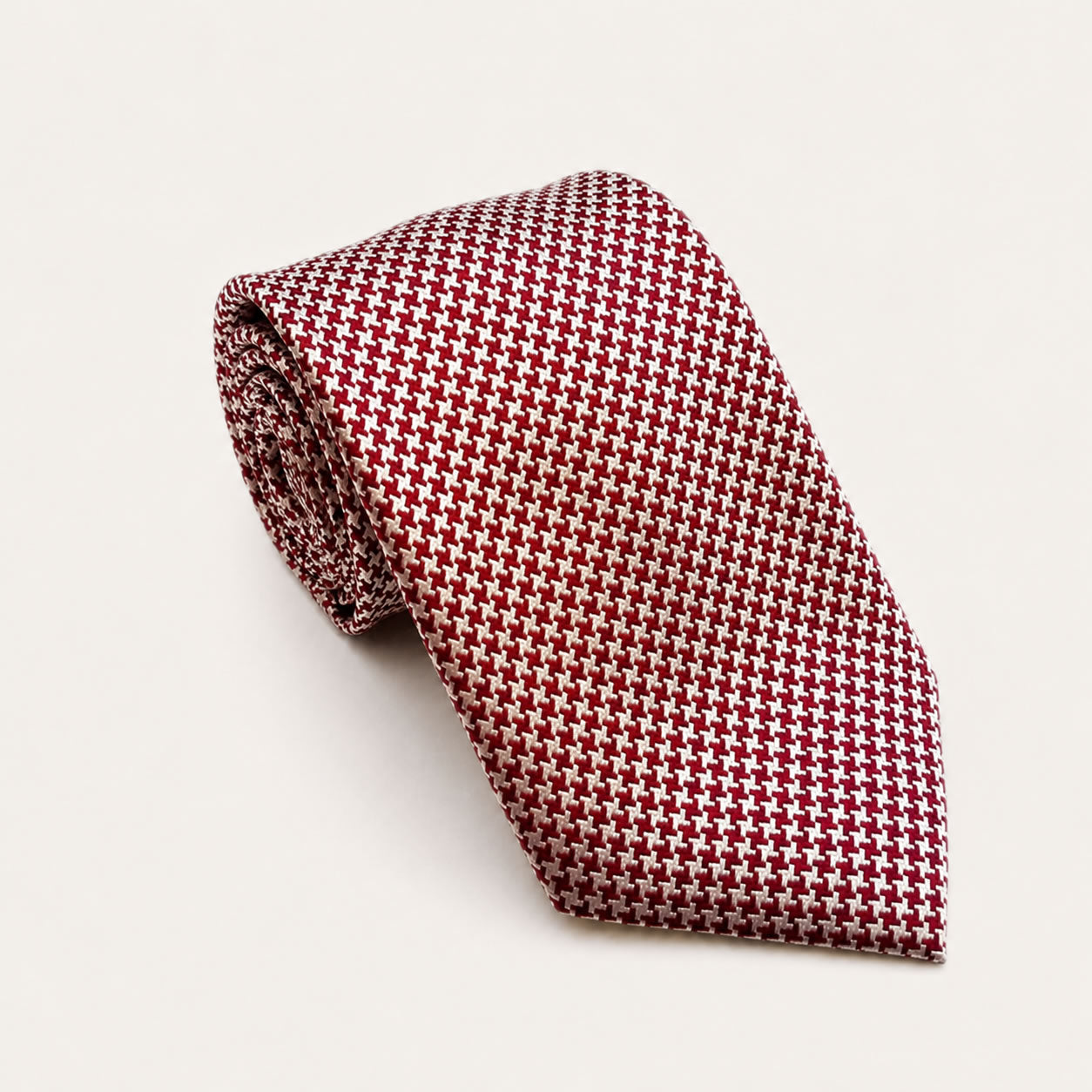 A rolled George Neale red and cream patterned silk tie.