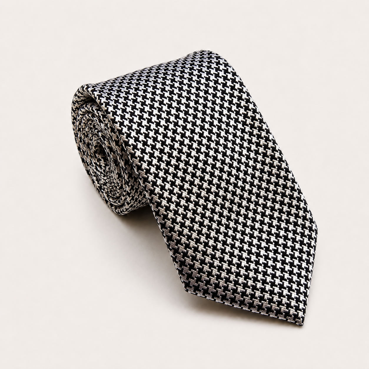 A rolled George Neale black and cream patterned silk tie.