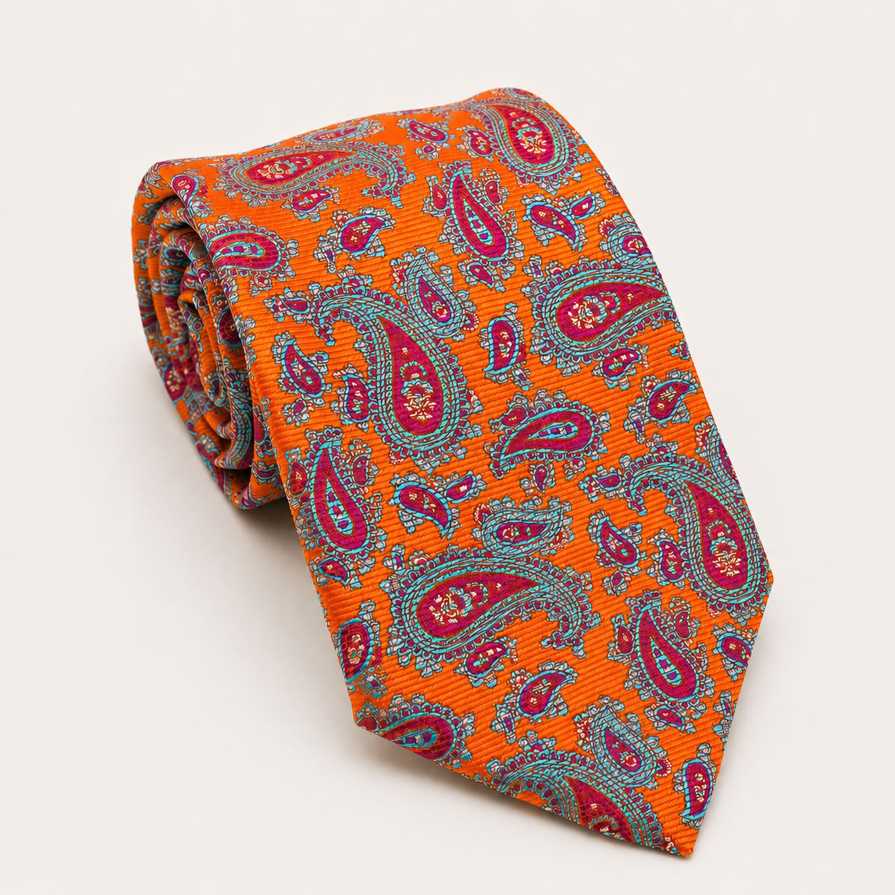 A rolled George Neale orange and pink paisley silk tie.