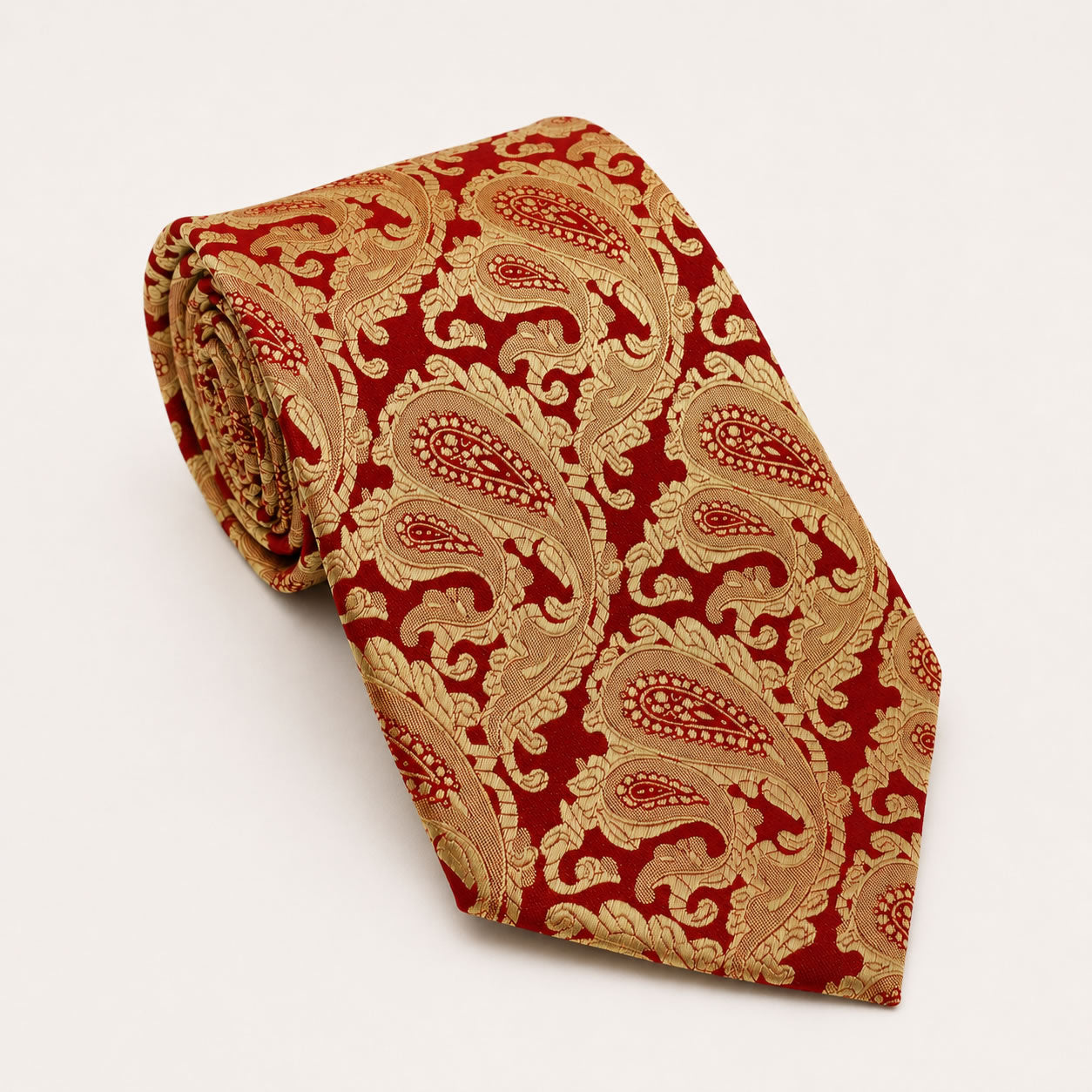 A rolled George Neale red and gold paisley silk tie.