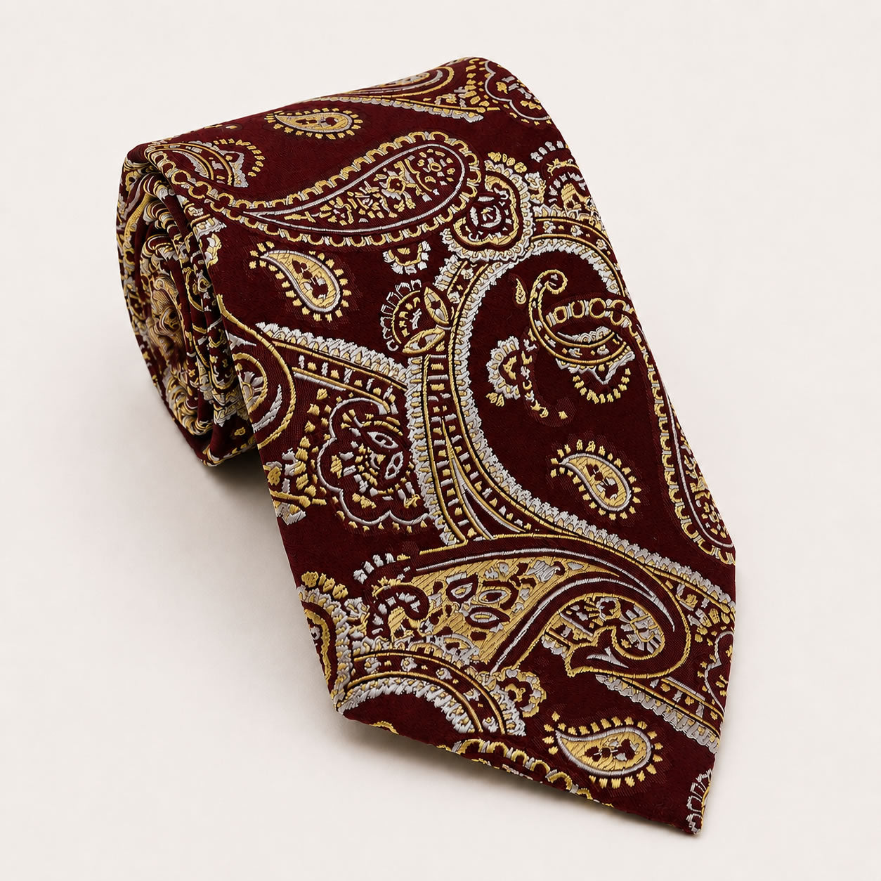 A rolled George Neale burgundy and gold paisley silk tie.