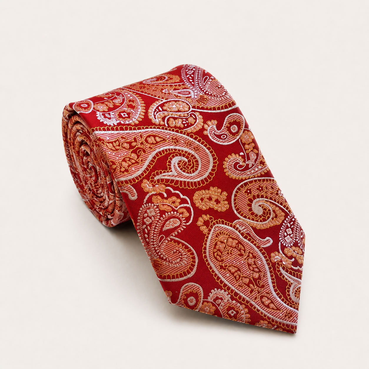 A rolled George Neale red and gold paisley silk tie.