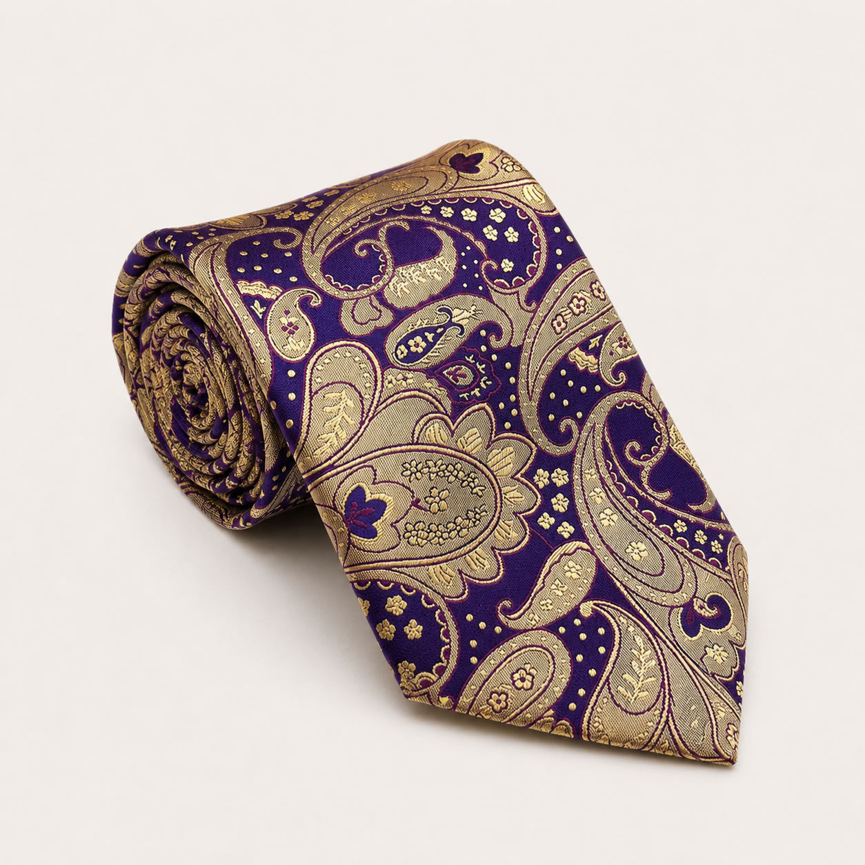 A rolled George Neale purple and gold paisley silk tie.