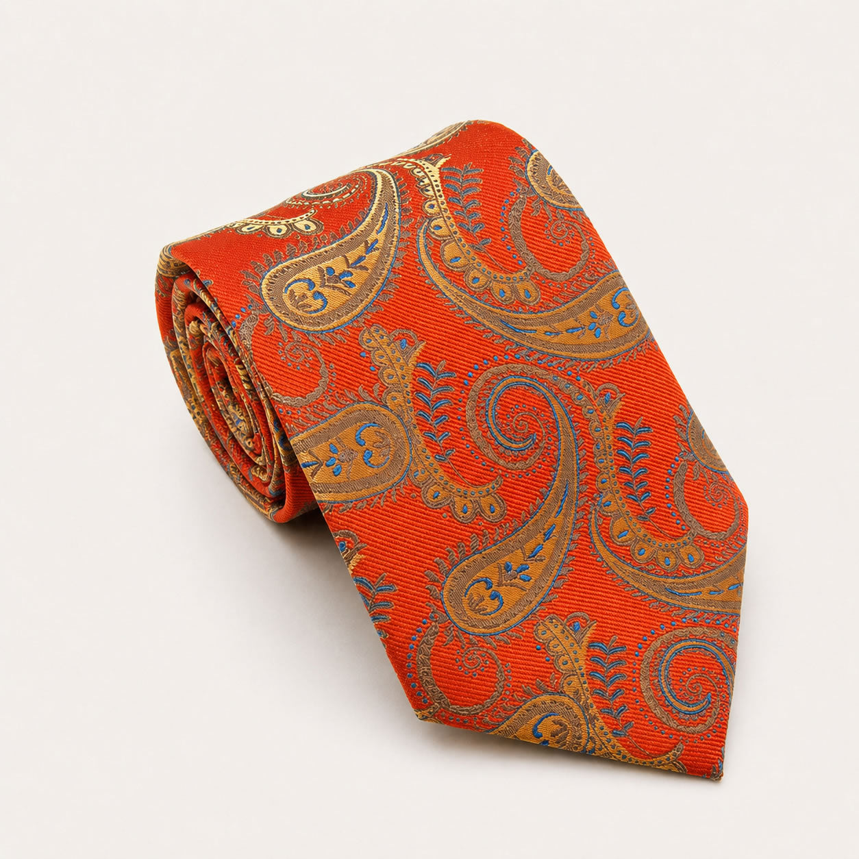 A rolled George Neale orange and gold paisley silk tie.