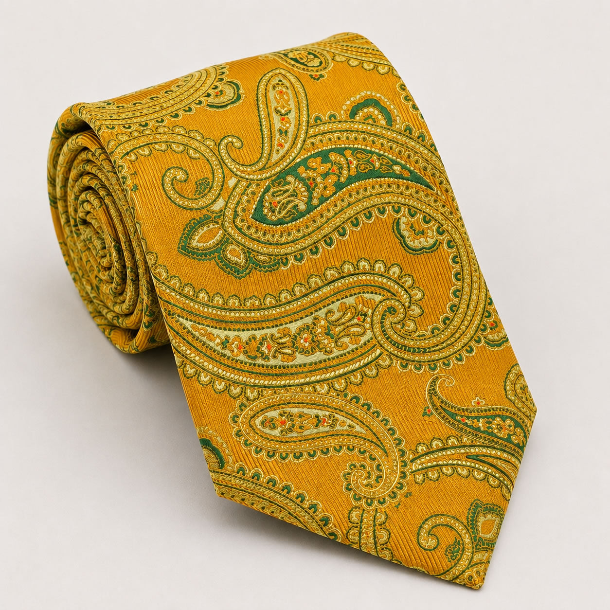A rolled George Neale gold and green paisley silk tie.