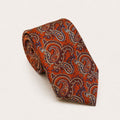 A rolled George Neale burnt orange and blue paisley silk tie.