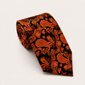 A rolled George Neale orange and black paisley silk tie.