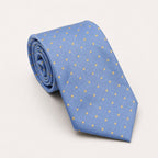 A rolled George Neale light blue and gold polka dot silk tie.