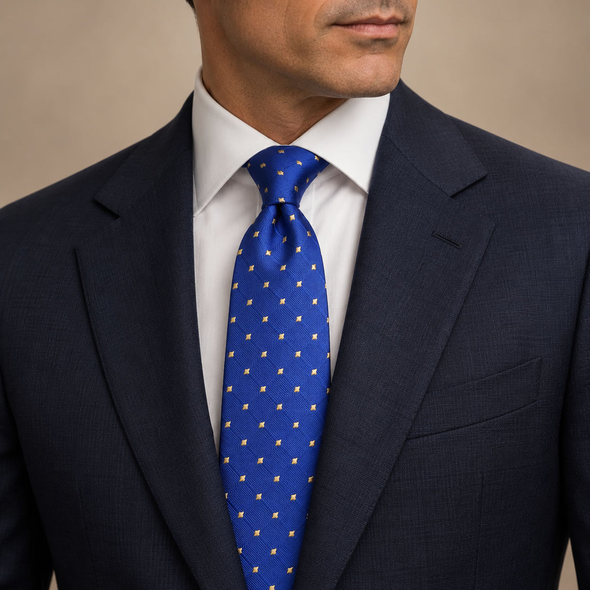 Royal Blue and Gold Polka Dot Silk Tie by George Neale, worn by a model with a suit and shirt