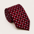 A rolled George Neale burgundy and light blue polka dot silk tie.