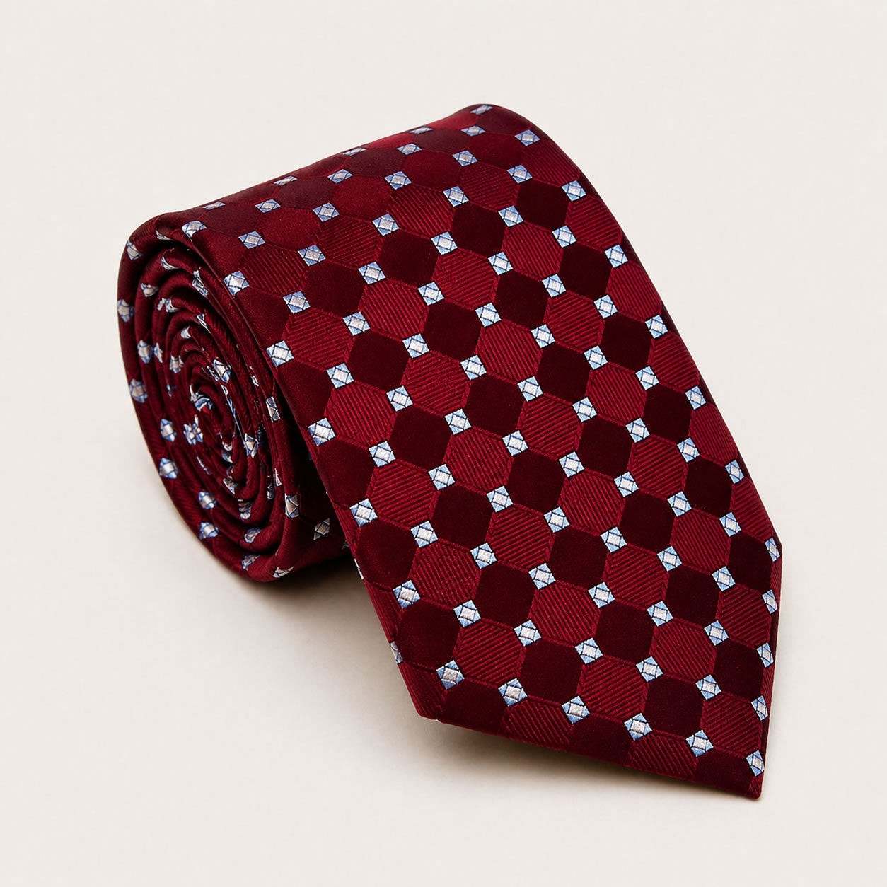 A rolled George Neale burgundy and light blue polka dot silk tie.