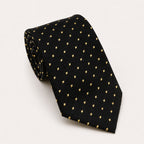 A rolled George Neale black and gold polka dot silk tie.
