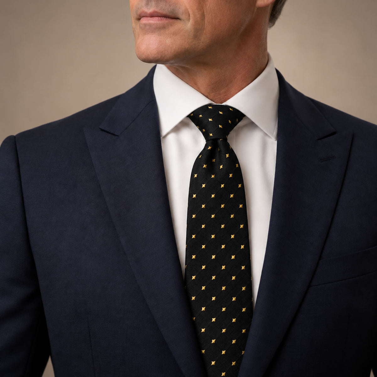 Black and Gold Polka Dot Silk Tie by George Neale, worn by a model with a suit and shirt