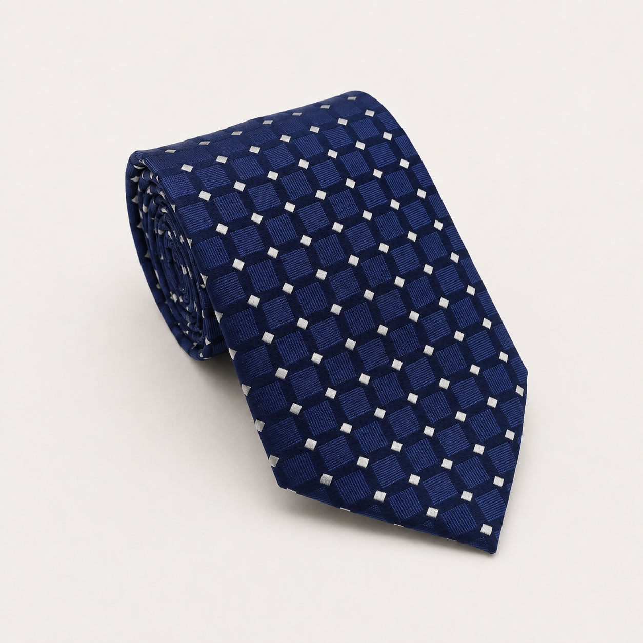 A rolled George Neale blue polka dot silk tie.