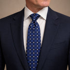 Blue Polka Dot Silk Tie by George Neale, worn by a model with a suit and shirt
