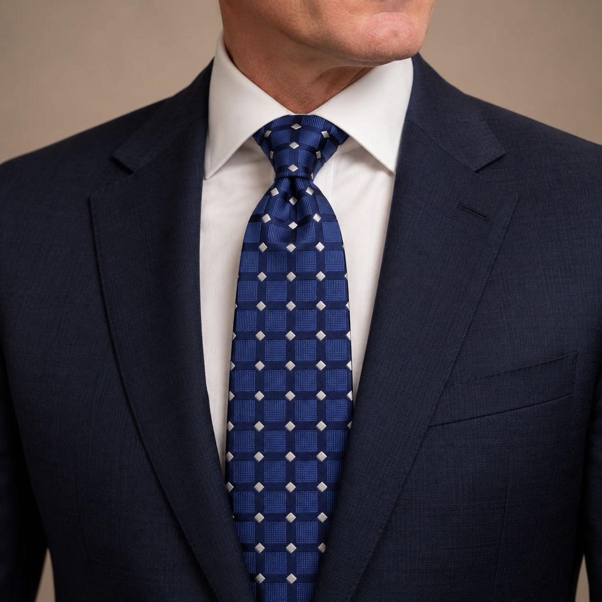 Blue Polka Dot Silk Tie by George Neale, worn by a model with a suit and shirt