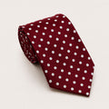 A rolled George Neale red and white polka dot silk tie.