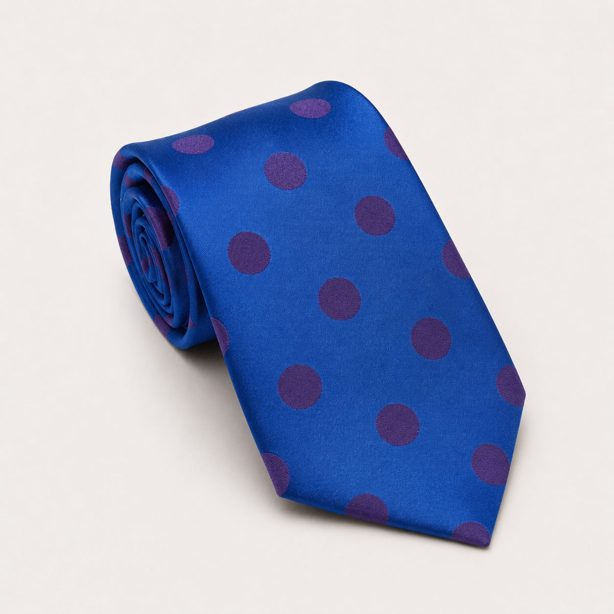 A rolled George Neale blue and purple polka dot silk tie.