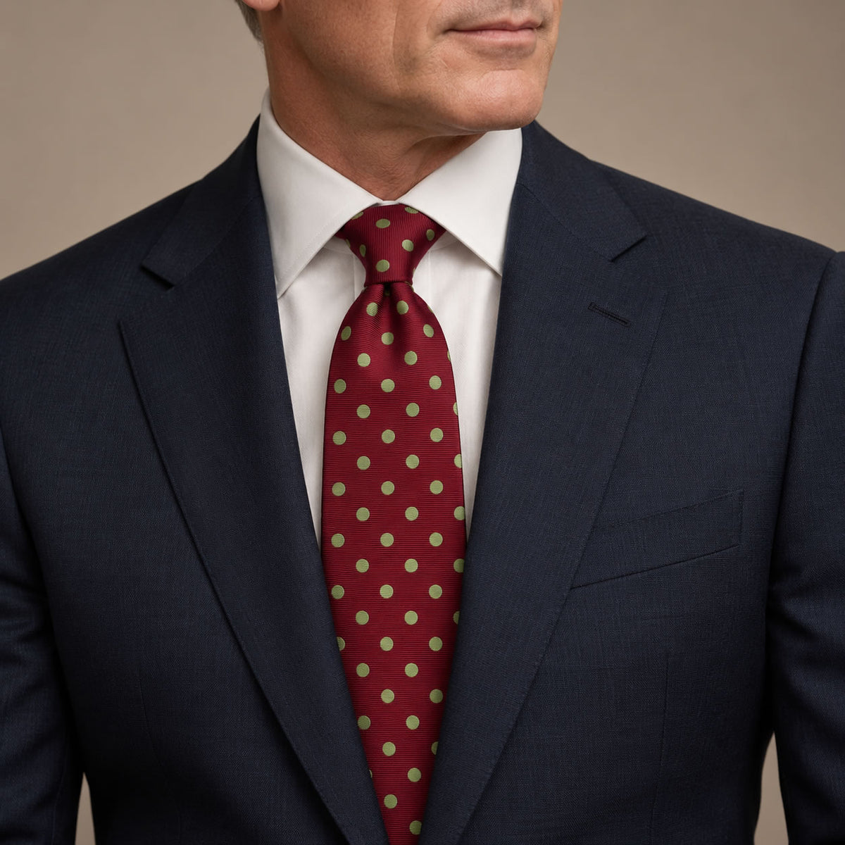 Burgundy and Green Polka Dot Silk Tie by George Neale, worn by a model with a suit and shirt