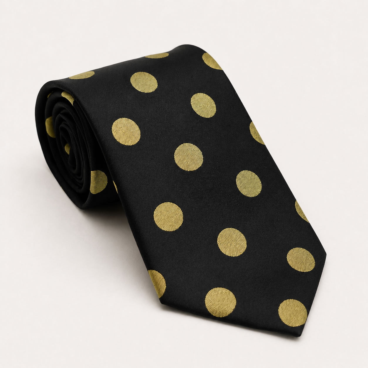 A rolled George Neale black and gold polka dot silk tie.