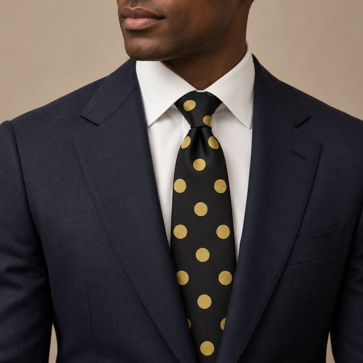 Black and Gold Polka Dot Silk Tie by George Neale, worn by a model with a suit and shirt