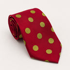 A rolled George Neale red and gold polka dot silk tie.
