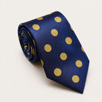 A rolled George Neale navy and gold polka dot silk tie.
