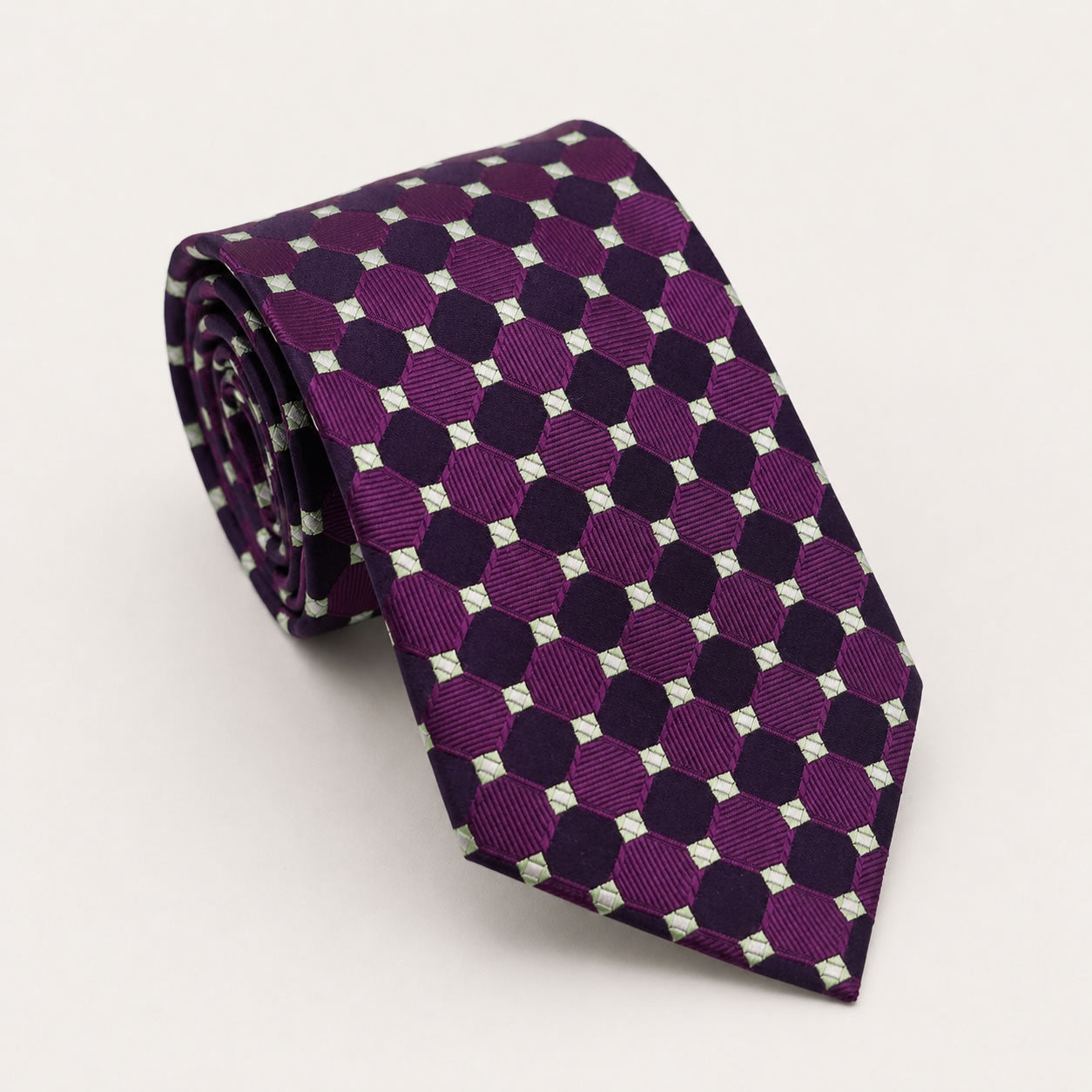 A rolled George Neale purple and green polka dot silk tie.