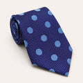 A rolled George Neale blue polka dot silk tie.
